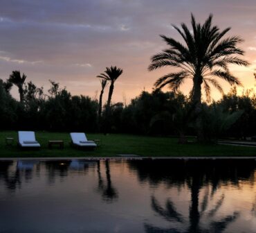 Marrakech all-inclusive club resort swimming pool in autumn, bathed in warm, soft light, symbolizing a peaceful and relaxing Moroccan getaway.