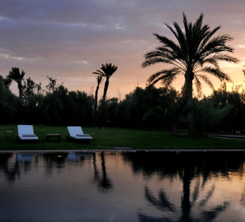 Marrakech all-inclusive club resort swimming pool in autumn, bathed in warm, soft light, symbolizing a peaceful and relaxing Moroccan getaway.