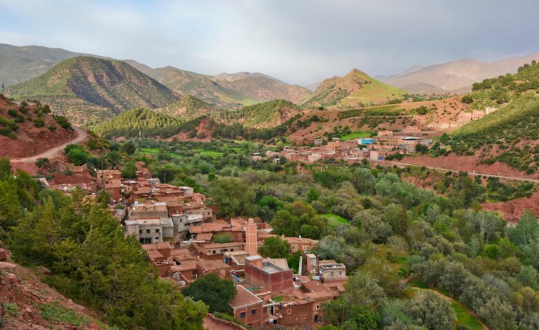 Scenic view of a traditional Berber village in the Ourika Valley, Atlas Mountains, a popular day trip destination from Marrakech, Morocco.
