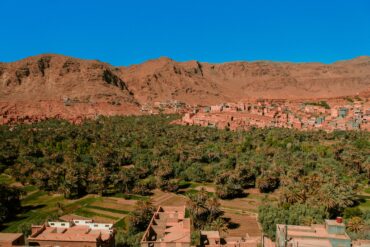 Scenic Atlas Mountains Morocco landscape with a traditional Berber village in a verdant valley, highlighting ideal day trips from Marrakech.